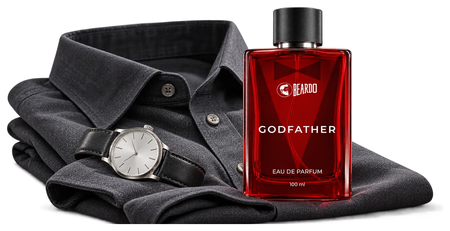The actual red Godfather perfume bottle beside a folded charcoal shirt and a plain watch.