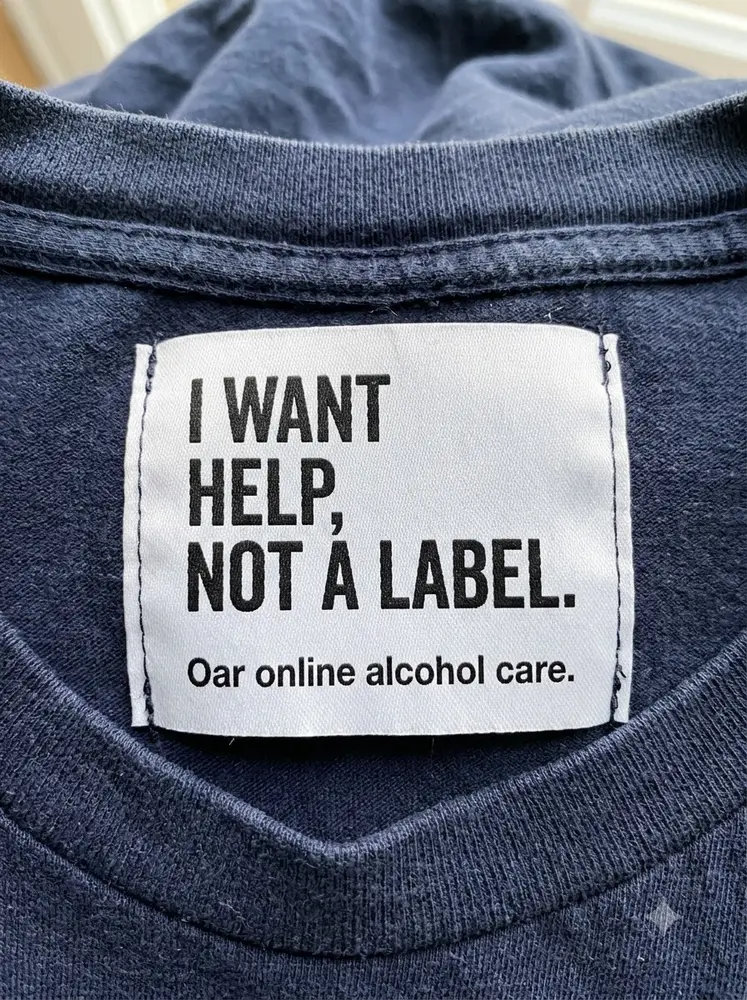 Help before labels. Sewn into a shirt. Made for Oar Health.